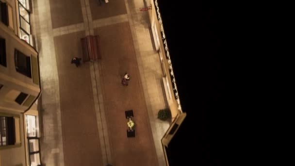 Rue lumineuse confortable avec des bâtiments de magasins jaunes éclairés et des personnes qui marchent — Video