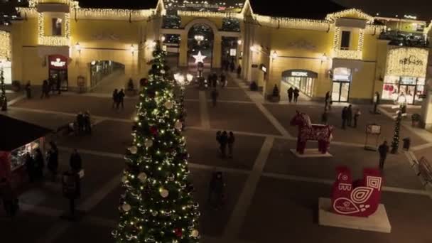 Increíble plaza pequeña con pino iluminado con decoraciones en la noche — Vídeo de stock