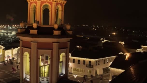 モスクワ ロシア連邦 2018 二重店建物照明 街路灯 寒い冬の夜の街の駐車場の暗い屋根金属ドームを輝かせてかわいい古い円形のタワー — ストック動画