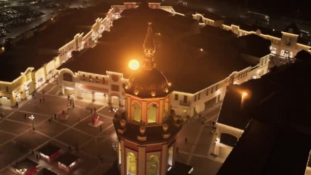 Hög byggnad med lysande gyllene kupol på lilla torget med julgran. — Stockvideo