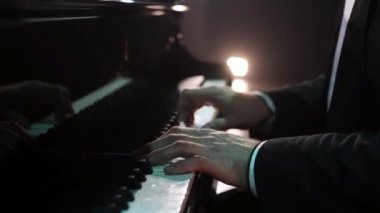 Takım elbiseli erkek piyanistler el görünümünü sahnede klasik piyano oynuyor