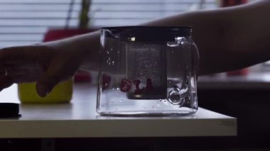 Kamera büyük kupa ve cam çaydanlık mutfak tabloda yerleştirilmiş olan tablo görüntüler.