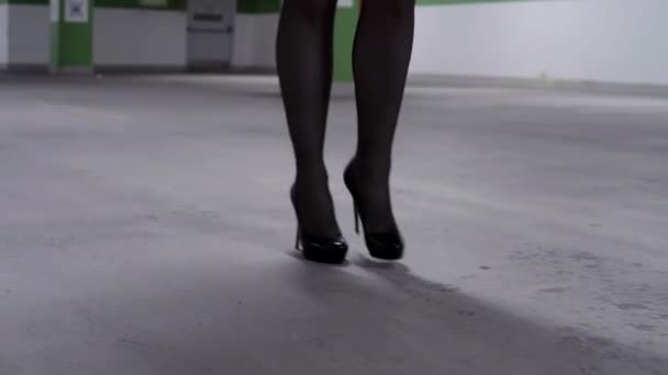 Sexy caminar piernas de mujer en medias negras y tacones altos en el garaje — Vídeo de stock