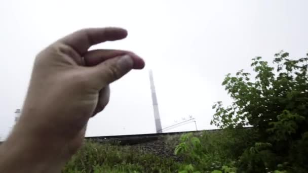 Någon går på trottoaren med kamera, pekar på rör, himmel och träd. — Stockvideo