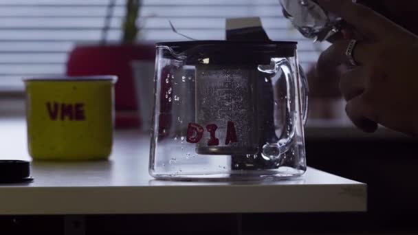養生茶葉は、キッチンのテーブルでガラスの急須に置かれています。. — ストック動画