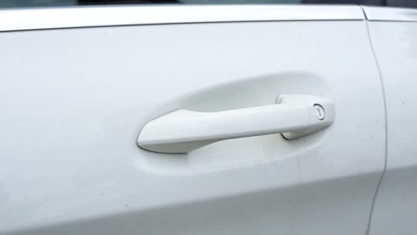 Kadın el tutamacını kapma tarafından modern beyaz arabanın kapısını açar. — Stok video