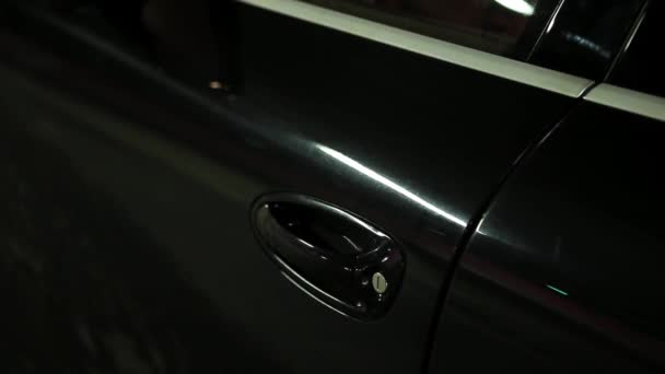 Alguma pessoa está abrindo a porta do carro preto, senta-se dentro e fecha-lo . — Vídeo de Stock