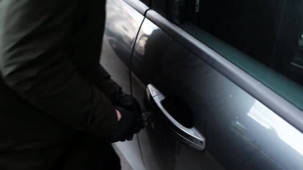 Vrouw met zwarte lederen handschoen proberen in te breken in de auto met behulp van metalen stick. — Stockvideo