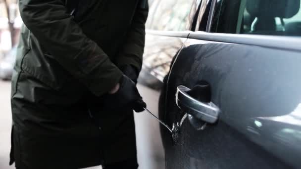 Mujer con guantes negros hace un gran agujero en la puerta del coche mediante el uso de palo metálico . — Vídeos de Stock