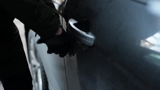Feminino com luva de couro preto tentando quebrar no carro usando pau metálico . — Vídeo de Stock