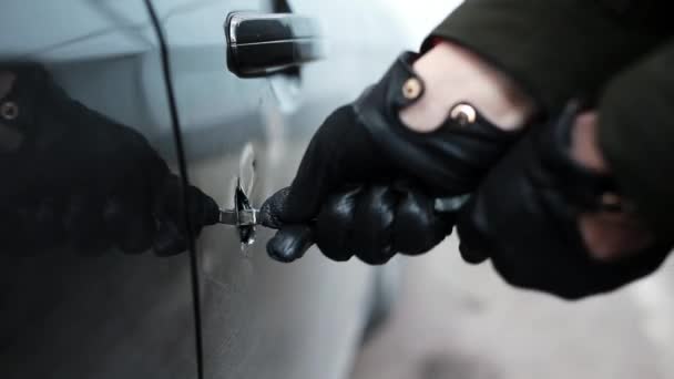 Handen in zwart lederen handschoen met metalen stick maken enorm gat in de deur van de auto. — Stockvideo