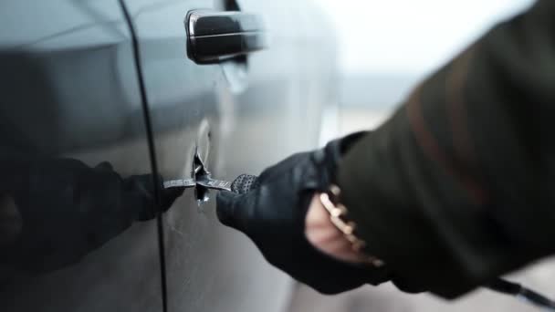 Osobę, czarne skórzane rękawiczki trzymając kij metalowy zrobić ogromny otwór w drzwiach samochodu. — Wideo stockowe