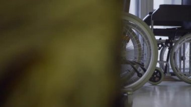Yavaş hareket koymak pencere eşiği yanında beyaz tekerlekli tekerlekli sandalye demet.