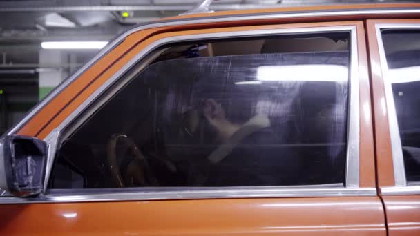 Volwassen bebaarde man met donker haar rode auto venster wordt geopend en begint sprekend. — Stockvideo
