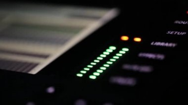 Yanıp sönen küçük yeşil ve kırmızı lambalar ile DJ radyo karıştırıcı panelinin yakın çekim parçası.