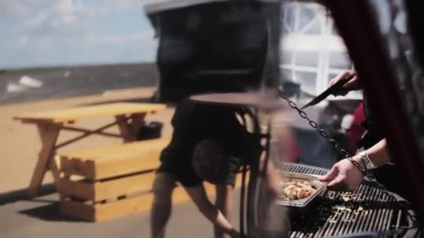 Hombre cocina profesionalmente fríe la carne blanca en la parrilla enorme en el restaurante al aire libre — Vídeos de Stock