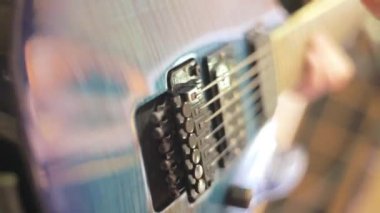 Guitar Player müzik stüdyosunda Elektrikli gitar dizeleri oynamak için pick kullanıyor.