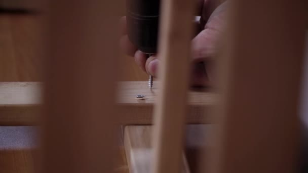 Чоловіки голі руки використовують сучасний електронний гвинтовий драйвер для з'єднання дощок — стокове відео