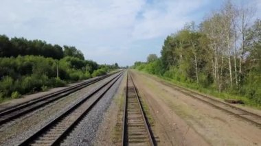 Çalılar ve ağaçlar yeşil hattı boyunca döşeme boş uzun Demiryolları güneşli sahne