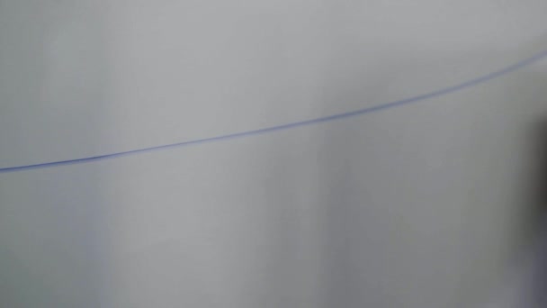 Чоловік малює довгу лінію до долара символ з кольоровим маркером на білій дошці . — стокове відео