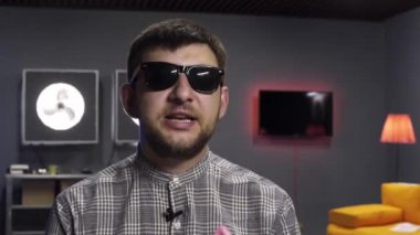 Yakışıklı erkek vlogger aktif konuşuyor ve gülümseme ile kamera kumbara tutar