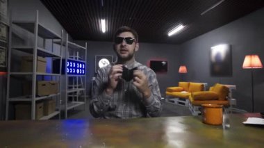 Genç blogcu konuşuyor ve yaşlı siyah deri cüzdanı kameranın önünde gösteriyor.