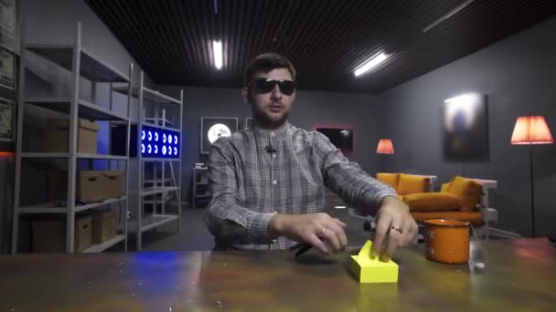 Joven bloguero pega pegatinas de papel amarillo a la superficie de la mesa marrón . — Vídeo de stock