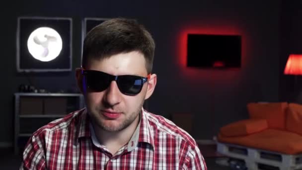 Netter Mann mit Sonnenbrille spricht, blickt in die Kamera, wirft Geldbörse mit Geld weg — Stockvideo
