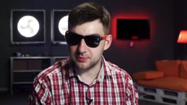 Güneş gözlüğü ile güzel görünümlü sakallı adam dinamik kamera konuşuyor