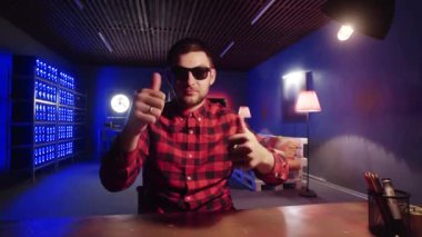 Sevimli adam masanın arkasında oturur, ışıklı soğutucular ile odada el hareketleri kullanın