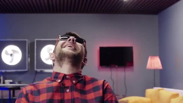 Guapo barbudo divertido chico usando gafas de sol en voz alta se ríe de cámara — Vídeo de stock