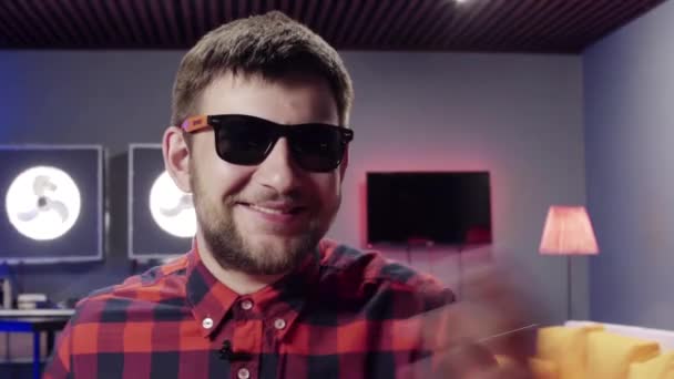 Vonzó kaukázusi szakállas fickó napszemüvegek hangosan nevet a kamera — Stock videók