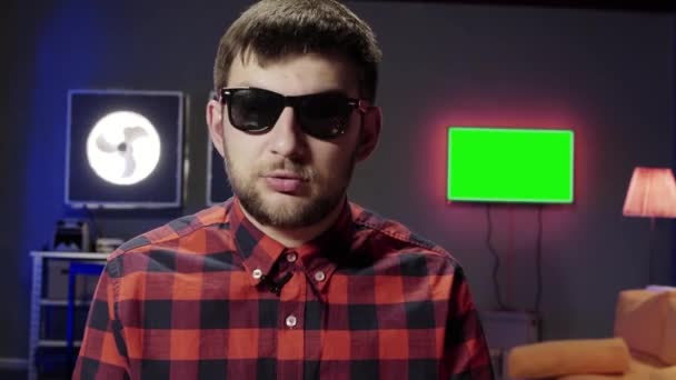 Ελκυστική γένια αστείος άνθρωπος βάλει στα γυαλιά ηλίου δυναμικά μιλά στην κάμερα — Αρχείο Βίντεο