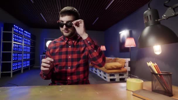 Netter grauäugiger Typ mit Bart, Sonnenbrille aufgesetzt, spricht und zwinkert in die Kamera — Stockvideo