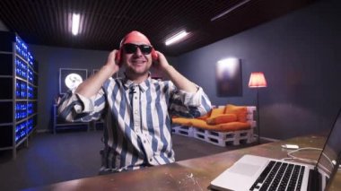 Güneş gözlüğü ile Gülümseyen sakallı adam masanın arkasında pembe yüzme şapkası koyarak