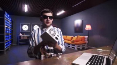 Çekici esmer adam soğutucu ile güç kaynağı kutusunu tutan kamera konuşuyor