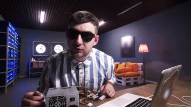 Genç adam kameraya konuşuyor. Elinde soğutuculu bir kutu var..