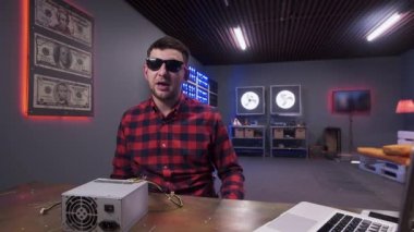 Yakışıklı genç adam soğutucu ile güç kaynağı kutusunu tutan kamera konuşuyor.