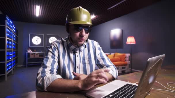 Handsome bearded man put on sunglasses and green safety construction helmet. — Stock Video