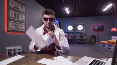 Zarflar beyaz laboratuvar önlüğü giyen güneş gözlüğü ile yakışıklı sakallı adam üzerine düşmek