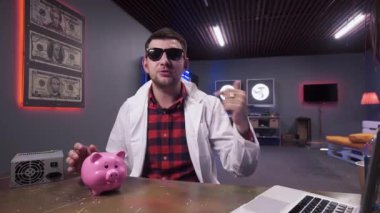 Laboratuvar önlüğü giymiş parlak aktif adam masada domuz ve dizüstü sahip konuşuyor