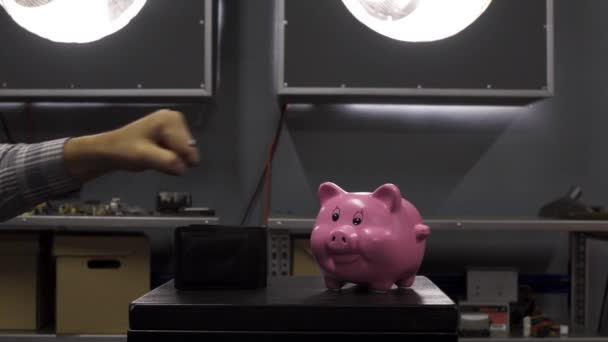 Mans hand demonstrates thumb down over wallet put on table with pink piggy bank — Stock Video