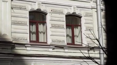 Kahverengi frramed pencereler ve yağmur oluk boru ile eski bej büyük binanın cephe