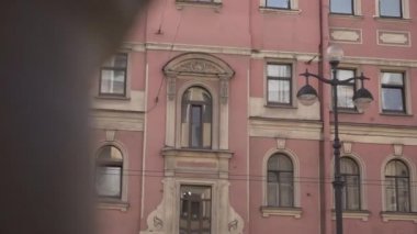 Güneşli bir günde birkaç pencere ile eski pembe tarihi binanın cepheleri