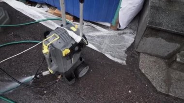 Bağlı hortumlar ile küçük mekanik pompa ünitesi asfalt zemin üzerine yerleştirilir