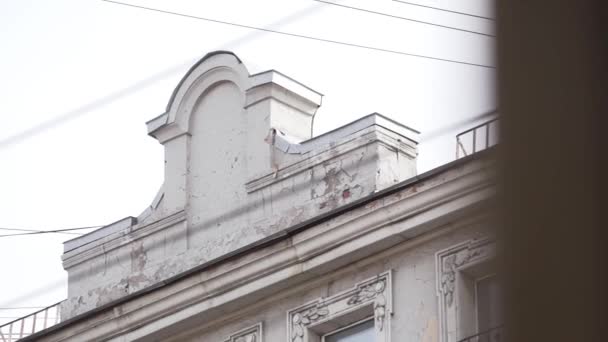 Фасад старої бежевої красивої будівлі з декількома вікнами і цікавим дахом — стокове відео