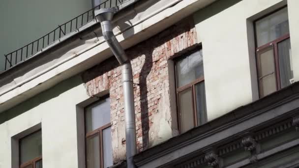 Gevel van oude beige rode bakstenen gebouw met verschillende ramen en regengoot pijp — Stockvideo