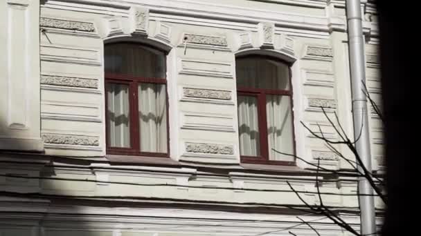 Fasáda staré béžové velké budovy s hnědými okny a trubkou na deště — Stock video