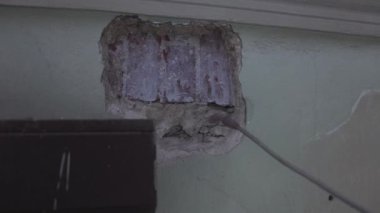 Ressamın elleri tuğla duvar parçasını hava boyası spreyi ile doğru bir şekilde kaplar.