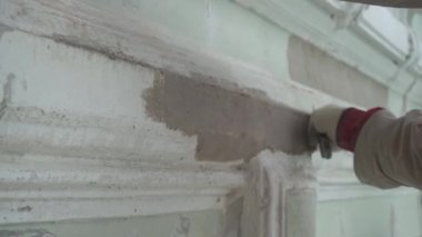 İnşaat işçileri elleri büyük spackle bıçak ile pürüzsüz sıva gri duvar